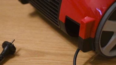 Elektrikli süpürge cihazına yakın çekim. Kavram. Elektrikli süpürge güç kablosunu kendine çeker. Elektrik kablosu küçük bir elektrik süpürgesinin arkasına çekilir.