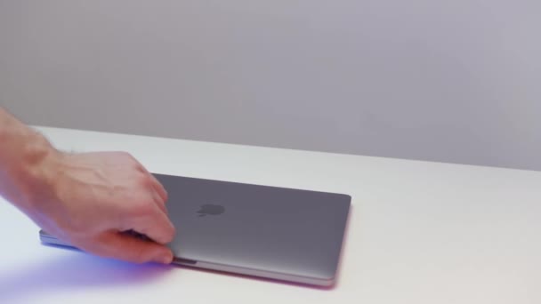 New York - ABD, 02.20.2021: Yeni Mac Apple dizüstü bilgisayarını gösteren erkek eline yakın çekim. Başla. Beyaz masada duran yeni bir MacBook Pro sunumu. — Stok video