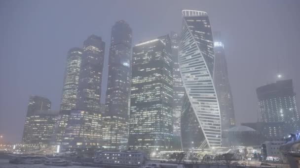 Башни Москвы в снежную холодную погоду. Начали. Высотные высотки со стеклянными окнами поздним зимним вечером, Москва, Россия. — стоковое видео