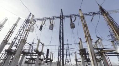 Mavi gökyüzü arka planındaki elektrik hatlarının alt görüntüsü. Başla. Yüksek voltajlı elektrik hattı şehirlere elektrik sağlıyor..