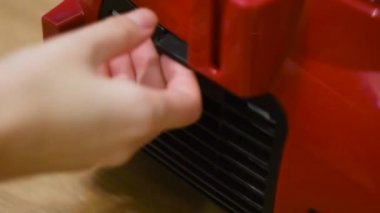 Elektrikli süpürge cihazına yakın çekim. Kavram. Ev sahibi kontaminasyon kontrolü için elektrik süpürgesinin arkasını çeker. Temiz elektrik süpürgesi filtresi