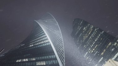 Karlı ve soğuk havada Moskova şehir kulelerinin alt manzarası. Başla. Kış akşamları camlı camlı gökdelenler.