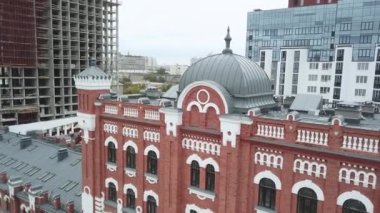 Şehrin arka planındaki güzel kırmızı tuğla binanın üst manzarası. Stok görüntüleri. Şehir merkezindeki eski kırmızı tuğlalı bina. Şehir merkezindeki mimari anıtın yenilenmiş binası