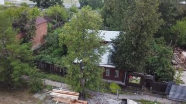 Yeşillikte eski ahşap bir ev. Stok görüntüleri. Yeşil çalılıkların arka planında ahşaptan yapılmış eski bir kulübe. Yazın yeşil ağaçların arka planında ahşaptan yapılmış eski kır evi