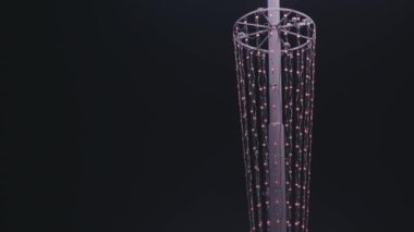 Arka planında çelenk olan sokak lambası. Stok görüntüleri. Sokak lambası şehir sokaklarının güzelliği için çelenkle süslenmiştir. Gece gökyüzünün arka planında çelenk parıltısı olan fener.