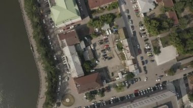 Binalar, evler, yeşil bitki örtüsü ve arabalı park yeri olan bir şehir caddesinin havadan görünüşü. Stok görüntüleri. Kentleşme kavramı.