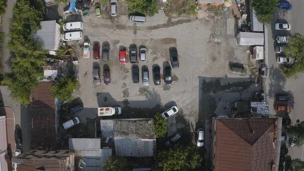 Area with parked cars and old houses. Stock footage. Top view of parked cars in old part of city on sunny day. Cars parked in front of old buildings