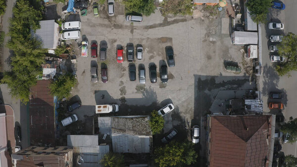 Area with parked cars and old houses. Stock footage. Top view of parked cars in old part of city on sunny day. Cars parked in front of old buildings.