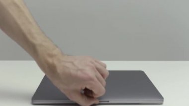 New York - ABD, 02.20.2021: Yeni Mac Apple dizüstü bilgisayarını gösteren erkek eline yakın çekim. Başla. Beyaz masada duran yeni bir MacBook Pro sunumu.