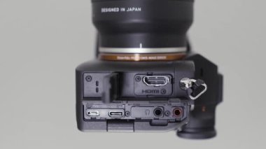 Farklı bağlantıları olan bir fotoğraf ve video kameranın üst görüntüsünü kapat. Başla. Beyaz arkaplanda izole edilmiş yeni bir kamera için slot makineleri, kulaklıklar ve USB tanıtımı.