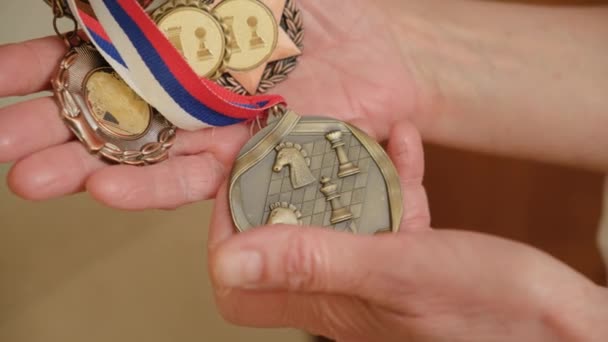 Close-up de medalhas desportivas. Imagens de stock. A idosa tem medalhas antigas. Medalhas de campeão de xadrez. Medalhas com xadrez — Vídeo de Stock