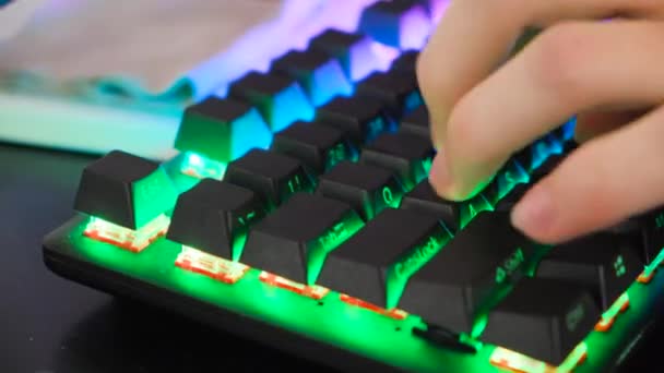 Klavyeye basan oyuncunun yakın çekimi. Stok görüntüleri. Profesyonel oyuncu için neon klavye. Oyuncu parlayan klavyenin tuşlarına basar — Stok video