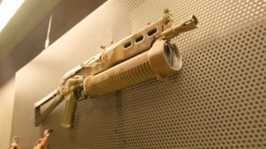 Silahlar duvarda asılı. Stok görüntüleri. Duvarda farklı tipte renkli silahlar asılı. Ateş etmek için silahlarla dolu duvar. Paintball ya da hava yumuşağı oynamak için silahlarla dolu bir duvar.