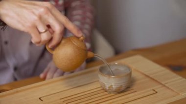 Çin çayı dolduran adama yakın çekim. - Sanat. Ahşap tepside küçük çaydanlıklı geleneksel Çin çayı. Bir kişi için çay seremonisi