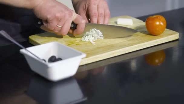 Close-up of chef slicing ingredients for dressing. Art. Professional chef cuts ingredients for salad or dressing finely. In kitchen with chef — Stock Video