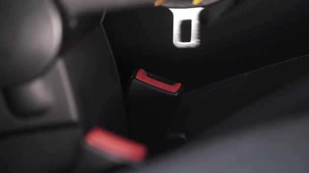 Kvinnlig hand spänner fast ett säkerhetsbälte i en bil. Börja. Närbild av kvinnlig hand med ljusgul manikyr fastsättning säkerhetsbälte. — Stockvideo