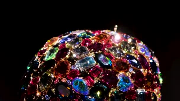 Närbild av roterande vackra smycken tillverkade av färgglada kristaller eller ädelstenar isolerad på svart bakgrund. Begreppet. Konst och lyx kvinnliga smycken, detaljer i en ring eller en brosch. — Stockvideo
