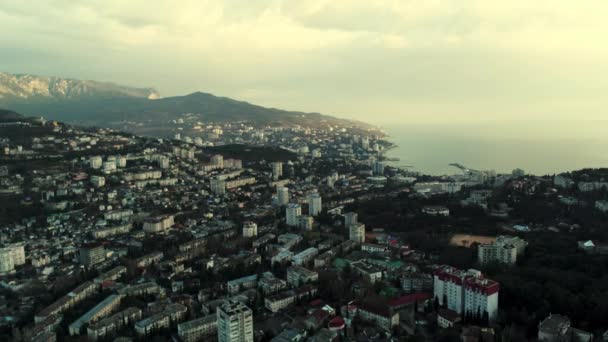 Aerial morning skyline over the city located by the sea. Shot. Breathtaking landscape with a early morning haze above the coastal town and calm water surface. — Stock Video