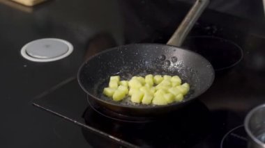 Patates kızartması ve yeşillik yakın çekim. - Sanat. Profesyonel şef basit patates ve fasulyeli yemekleri hazırlar. Aşçı kızarmış patatese yeşil fasulye kabuğu koyar.