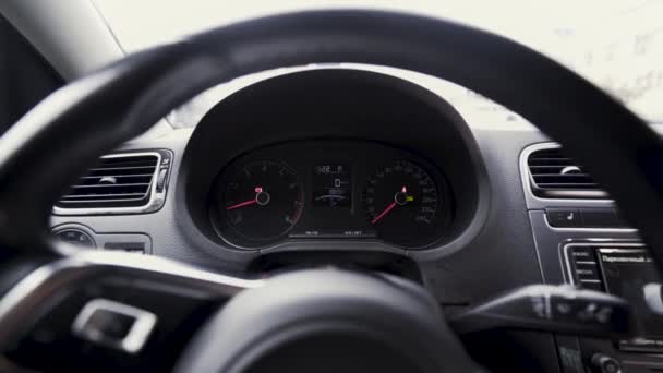 Vista interior de un vehículo de pasajeros con un salpicadero detrás de un volante. Acción. Primer plano de las escalas de velocidad del motor, concepto de transporte. — Vídeos de Stock