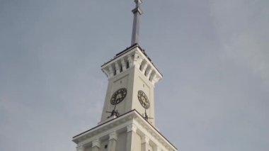 Mavi bulutlu arka planda uzun bir kulesi olan bir saat kulesinin alt görüntüsü. Başla. Tarihi bir binanın detayları..