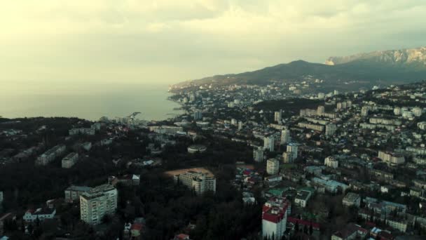 Deniz kıyısındaki şehrin üzerinde havadan sabah silueti. Vuruldu. Sabahın erken saatlerinde kıyı kasabasının üzerinde puslu bir hava ve sakin bir su yüzeyi ile nefes kesici bir manzara.. — Stok video