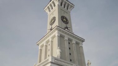 Mavi bulutlu arka planda uzun bir kulesi olan bir saat kulesinin alt görüntüsü. Başla. Tarihi bir binanın detayları..