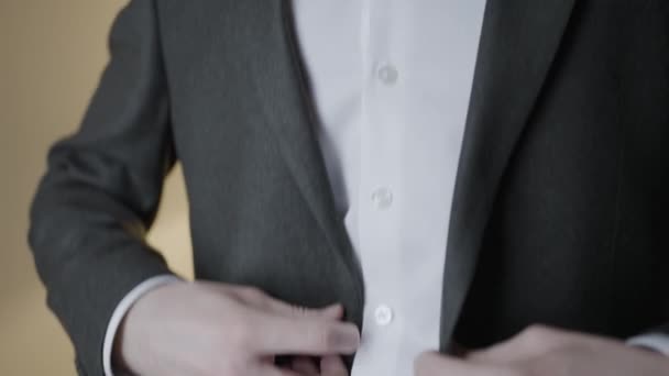 Κοντινό πλάνο του τζέντλεμαν προσαρμογή σακάκι κοστούμι. Πάμε. Ο ελκυστικός άντρας προσαρμόζει το σμόκιν πριν την γιορτή. Ο κύριος ισιώνει το σακάκι και το κουμπώνει. — Αρχείο Βίντεο