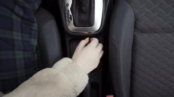 Conductora mujer controlando automóvil y tirando del freno de mano. Acción. Vista superior cercana de la mano femenina levantando el freno de mano y perdiéndolo. — Vídeo de stock