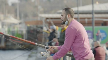 İSTANBUL, TURKEY - Mart 2021: Türkiye 'de Köprü Balıkçılığı. Başla. Güneşli bir günde Türk köprüsünde geleneksel balık avı. Türk Köprüsü Balıkçılığı