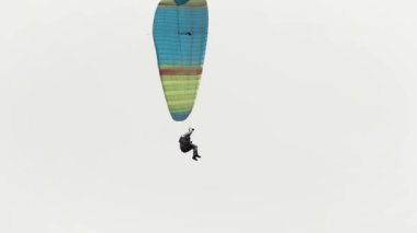 Ekstrem spor konsepti, gökyüzünde süzülen paraglider. Başla. Paraşütçü bulutlu arka planda süzülüyor.