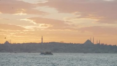 Günbatımında İstanbul sahilinin güzel manzarası. Başla. Güzel günbatımının arka planında camilerin gölgeleri olan sahilin resimli manzarası.