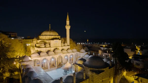 Mosque with lanterns at night. Action. Beautiful landscape of Turkish city with mosque illuminated by lanterns at night. Glowing mosque on background of Istanbul at night