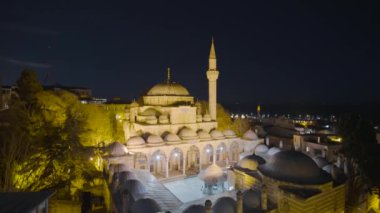 Geceleri fenerli cami. Başla. Gece fenerlerle aydınlatılan camii ile Türk kentinin güzel manzarası. İstanbul 'un arka planında gece parlayan cami