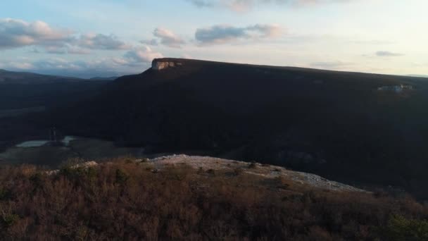 Luftaufnahme über erstaunliche Felsen und den Sonnenaufgang. Schuss. Atemberaubende Landschaft mit Steinklippen und der Ebene weit in der Ferne. — Stockvideo