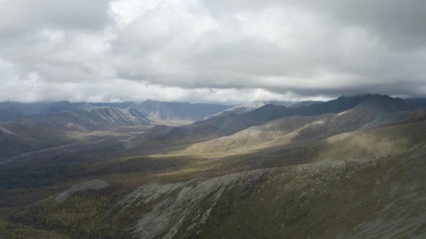 Vista aérea natural de las montañas cubiertas de hierba verde sobre un fondo nublado. Clip. Colinas altas y nubes pesadas, paisaje otoñal. — Vídeo de stock