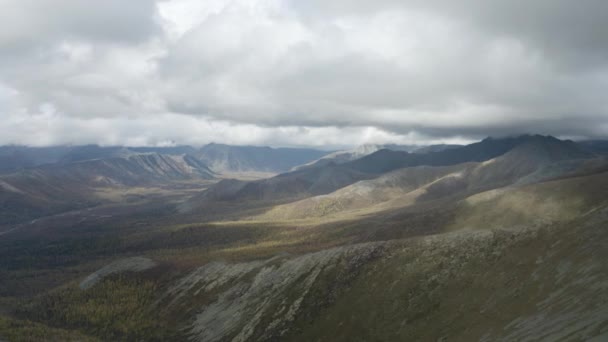 Aerial naturalny widok na góry pokryte zieloną trawą na zachmurzonym tle nieba. Klip. Wysokie wzgórza i ciężkie chmury, jesienny krajobraz. — Wideo stockowe