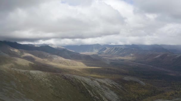 Vista aérea natural de las montañas cubiertas de hierba verde sobre un fondo nublado. Clip. Colinas altas y nubes pesadas, paisaje otoñal. — Vídeo de stock