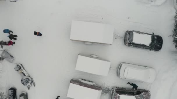 Aerial top view of a residential city courtyard after snowfall. Clip. Cars and snow mobiles covered by white snow on a winter day. — Stock Video