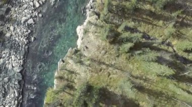 Kozalaklı yaz ormanlarında akan mavi, berrak bir nehrin üst hava manzarası. Şarjör. Doğal ortamda saf dağ suyu..