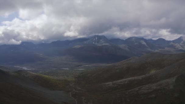 Flygfoto hisnande utsikt över en bergskedja och molnig himmel. Klipp. Naturlandskap med gröna backar tidigt på hösten. — Stockvideo