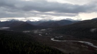 Ulusal park ve dağ zirvelerine yakın akan ağır bulutlarla sonbahar akşamı manzarası. Şarjör. Çam ağaçları boyunca kıvrılan nehirleri daralt.