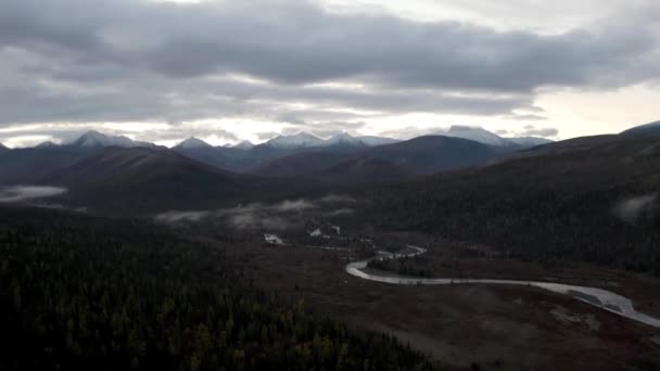 Paysage d'automne en soirée avec un parc national et de gros nuages qui coulent près des sommets montagneux. Clip. Rivière étroite courbant le long des épinettes. — Video