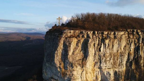 Пейзаж с скалой и крестом на вершине. Выстрел. Концепция религии, место веры и мира, воздушный вид на гору и крест. — стоковое фото