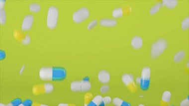 Ağır çekimde sarı arka plana düşen çok sayıda renkli hap ve tablet var. Animasyon. Çok renkli tıbbi ilaçlar, sağlık kavramı.