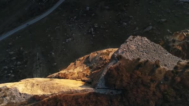 강렬 한 화강암 절벽 과말라버린 오렌지 풀 이 공중에서 찍은 놀라운 사진이었습니다. 총 맞았어. 가파른 산비탈 과 뒤에 있는 좁은 도로를 공중에서 내려다본 모습. — 비디오