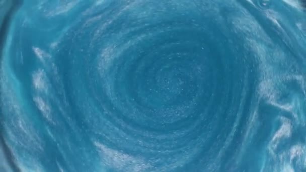 Sıvı mavi bir maddedeki parçacıkların güzel hareketi. Stok görüntüleri. Dönen fantastik renkli suyun üst görüntüsünü kapat.. — Stok video