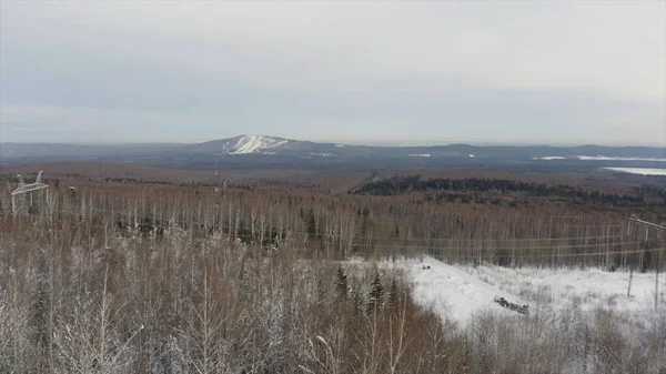 Vista aerea di una foresta ghiacciata con alberi innevati in inverno. Clip. Volo sopra foresta mista in Finlandia con montagne sullo sfondo. — Foto Stock