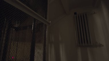 Eski, karanlık bir binada vintage bir asansör yukarı çıkıyor. Stok görüntüleri. Demir ızgaralı bir asansörün ev girişine bak..