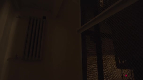 Un ascenseur vintage descend dans un vieux bâtiment sombre. Images d'archives. Vue à l'intérieur d'une maison entrée d'un ascenseur avec grille en fer. — Video